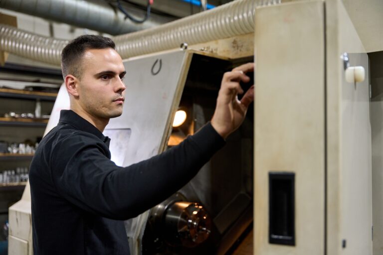 Metalworker operating cnc machine in factory workshop